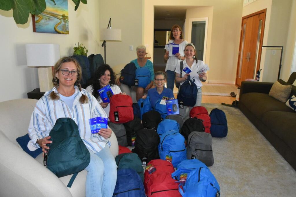 SI Davis members holding assembled backpacks for survivors of human trafficking and domestic violence, given at Empower Yolo and Sutter Health emergency rooms